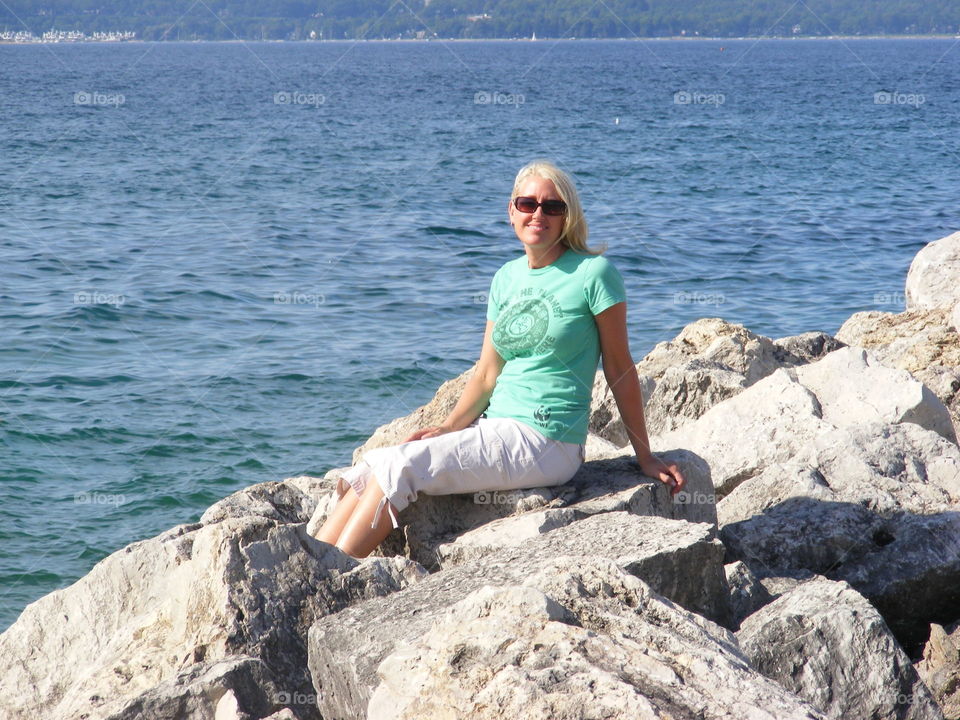 Woman posing on rocks next to Lake Michigan