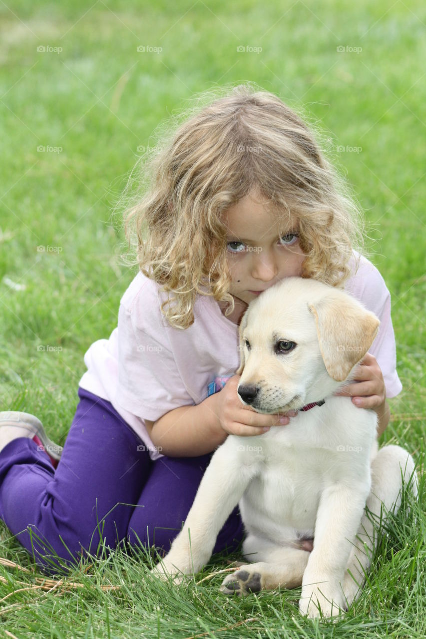 Puppy Love. White lab puppy and little girl