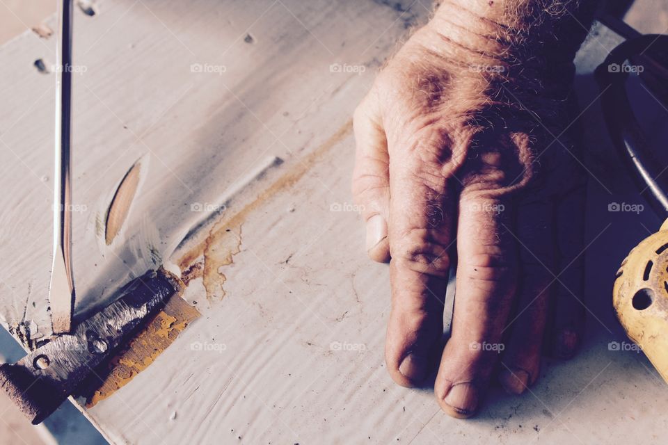 Close-up of carpenter's hand and screwdriver