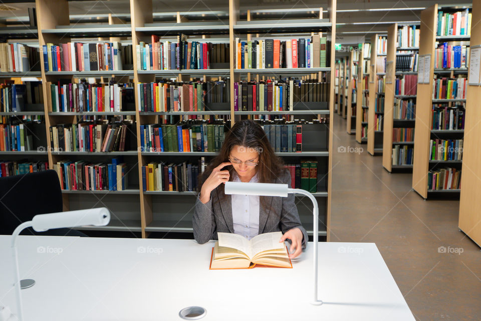 Girl reads a book in the library