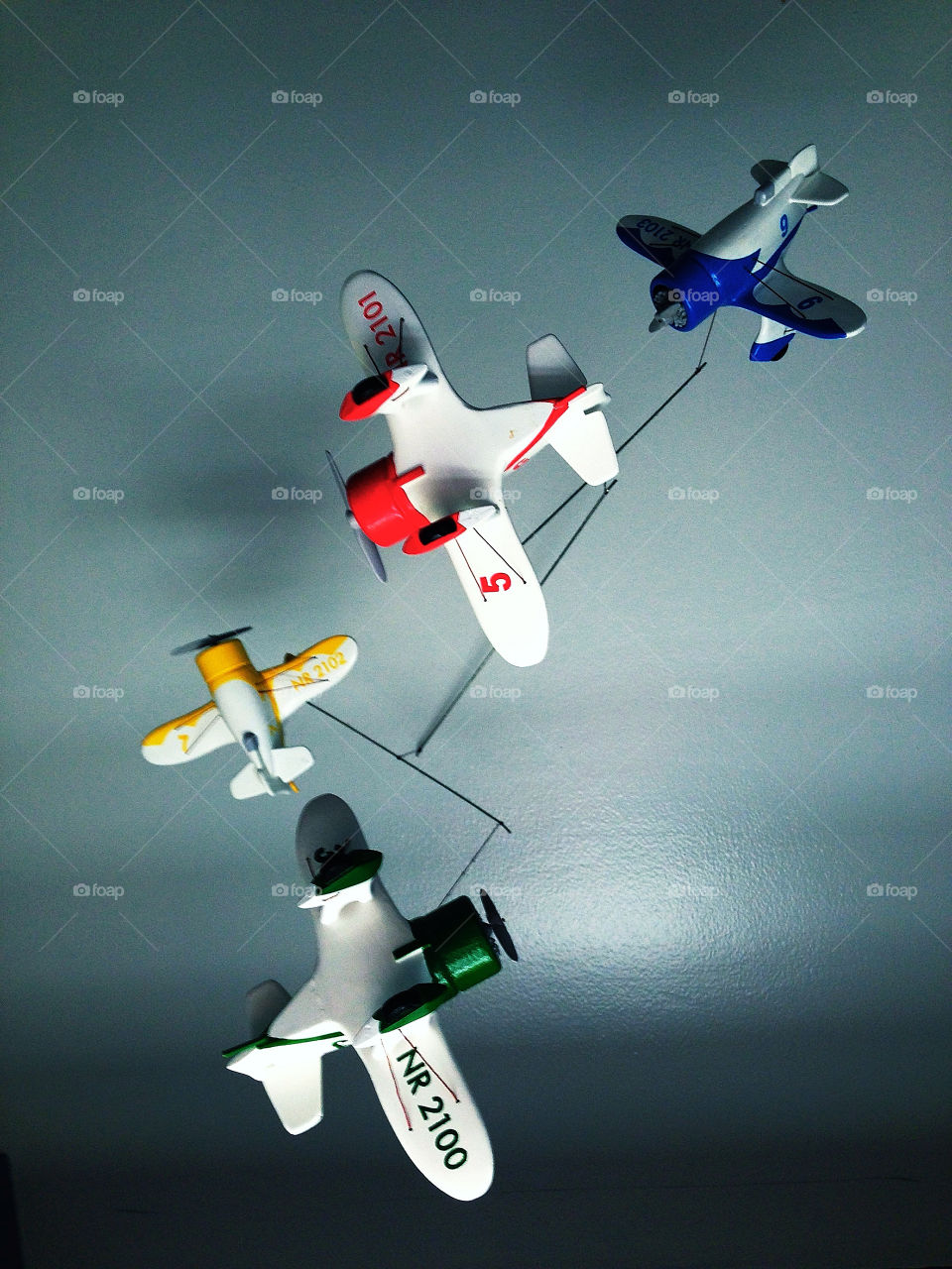 Four colorful Gee Bee racing planes in a mobile hanging from a home