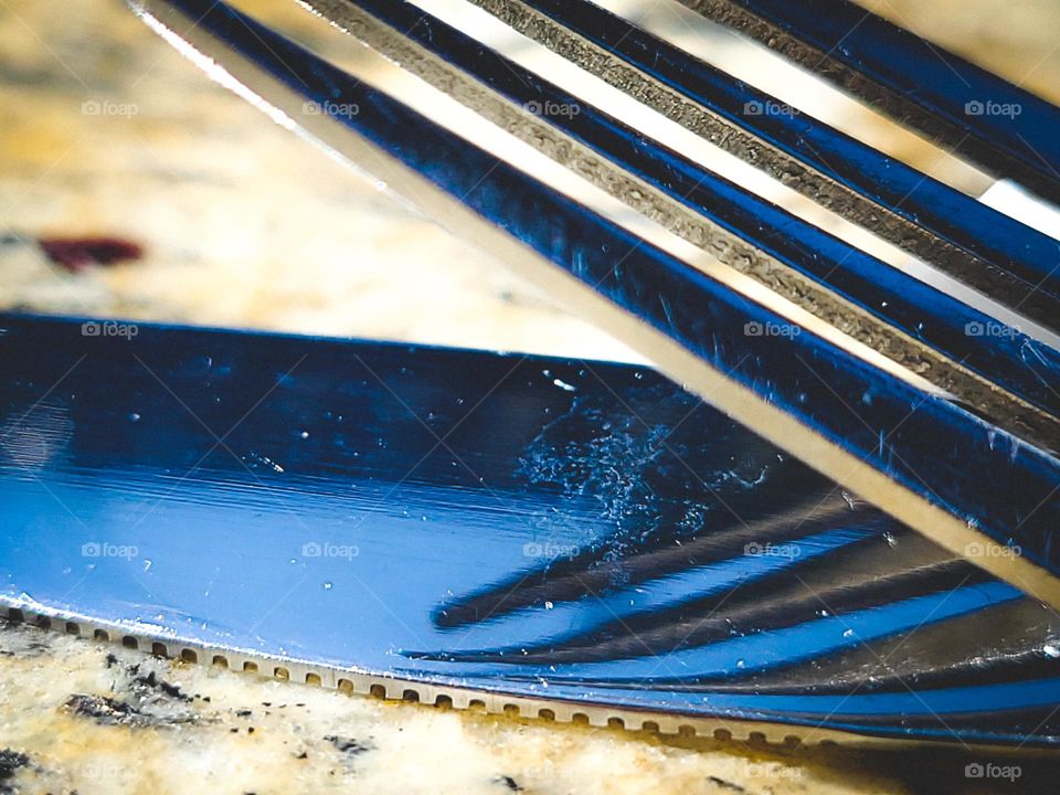 A fork is reflecting in the eyes of his knife forever linked together on the table 