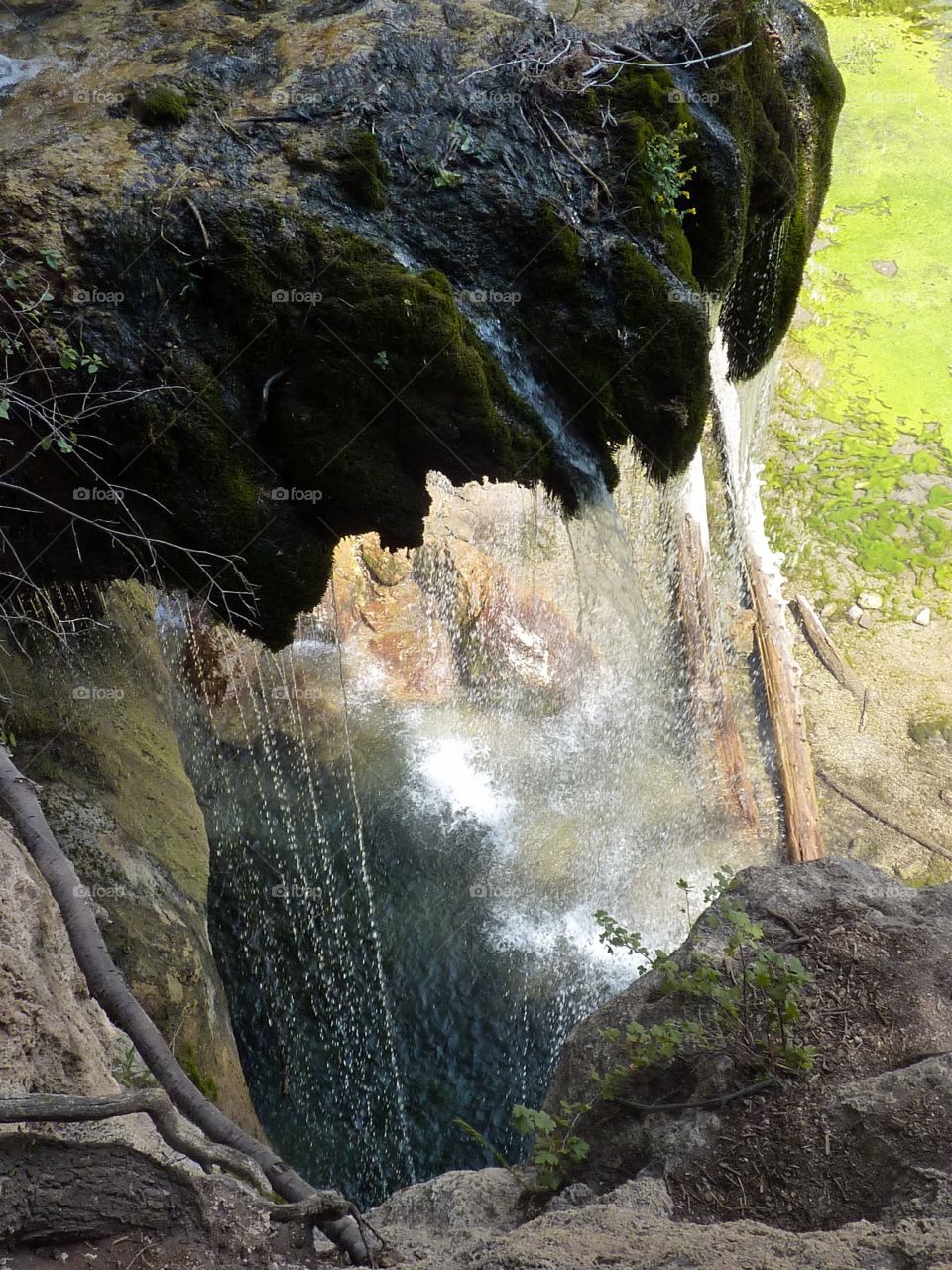 water slowly falling from mossy rocks