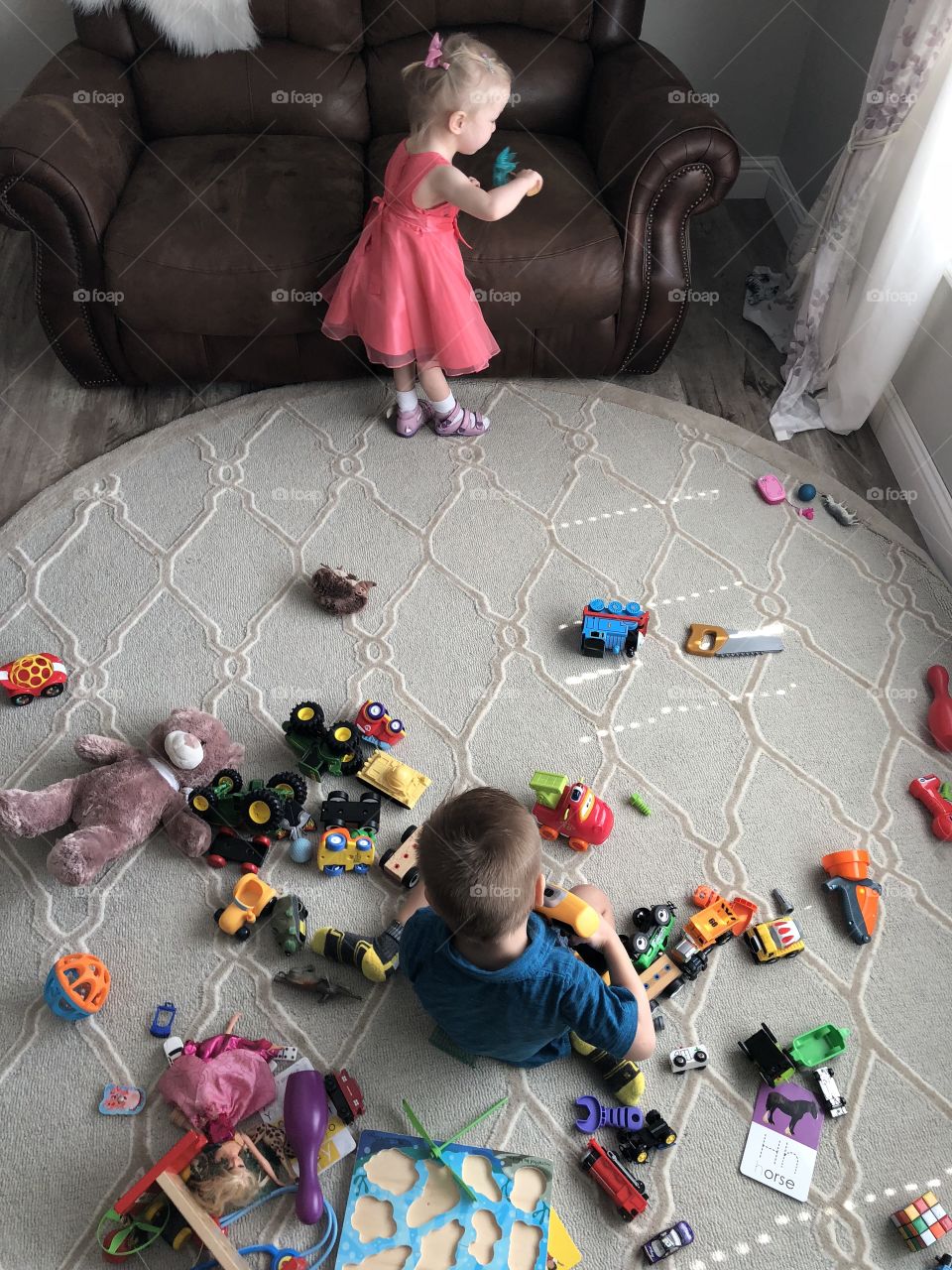 Brother and sister playing with toys 