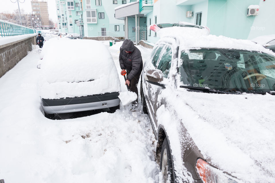 man removes snow with a shovel