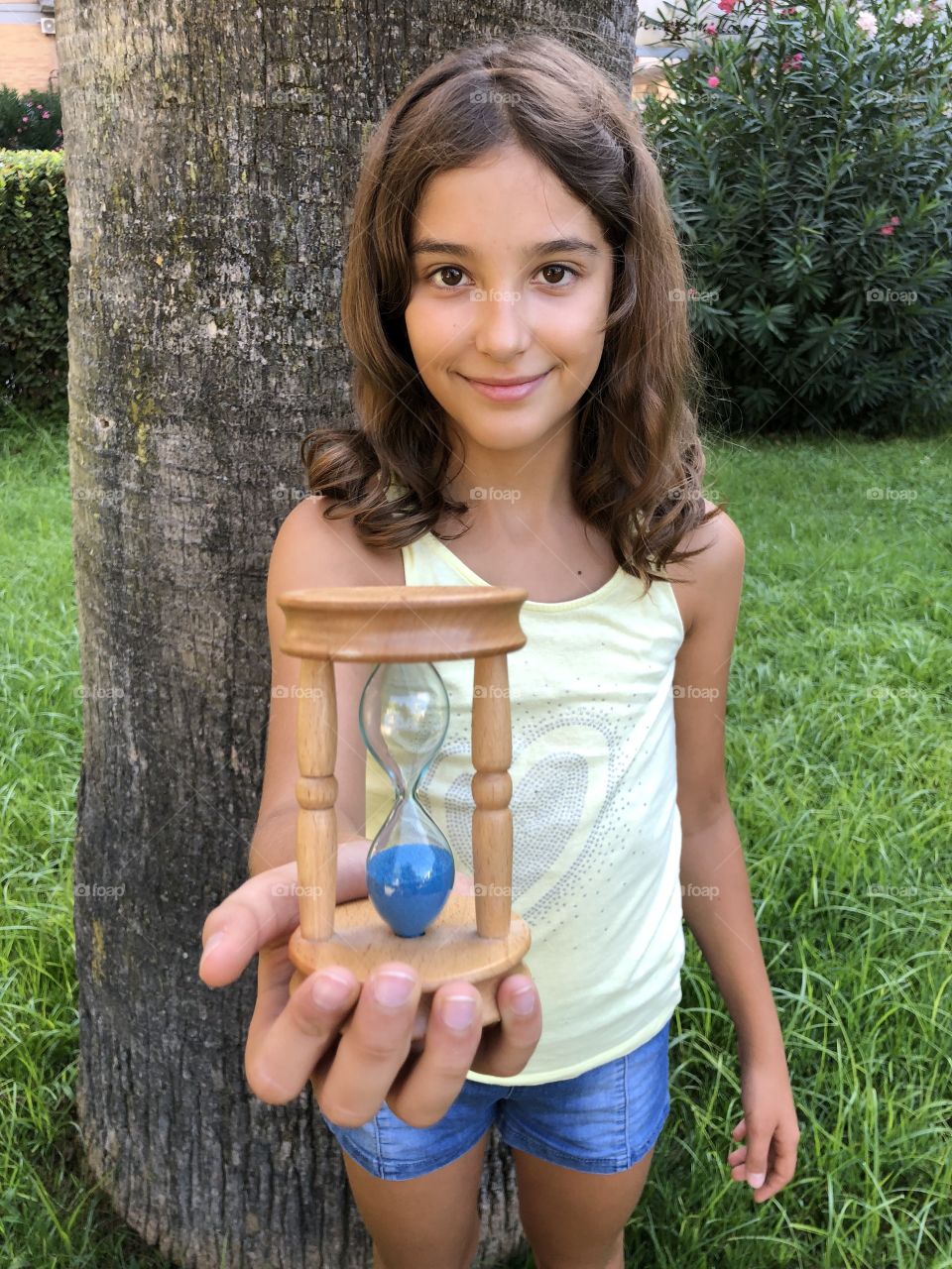 Young girl holding a clepsydra in her hand