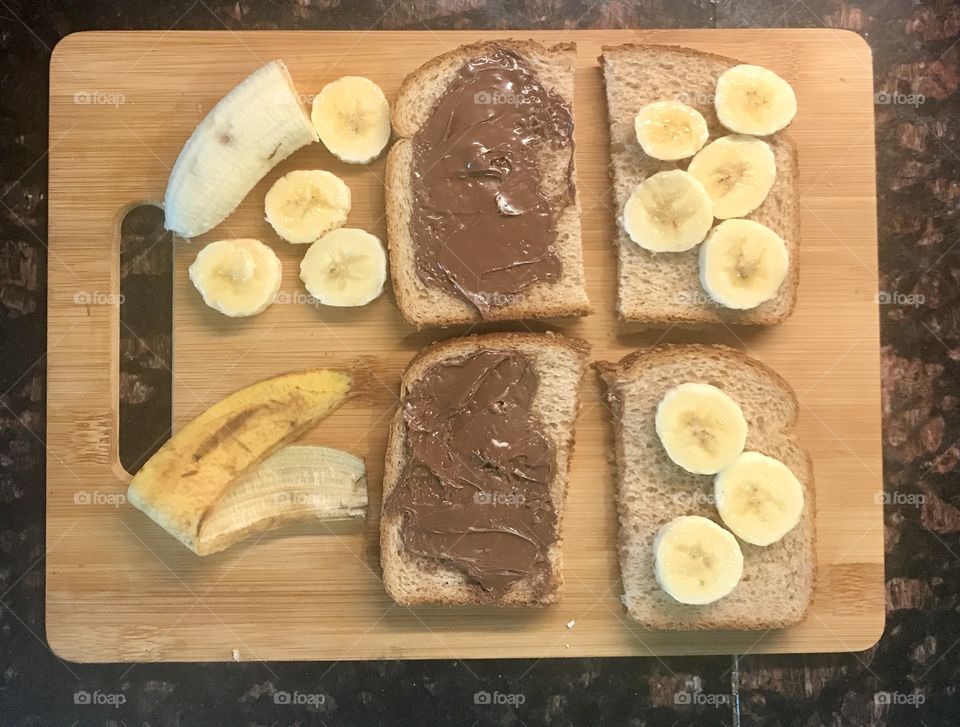 Yummy and delicious Nutella and banana sandwiches on display on the wooden cutting board for lunch. USA, America 