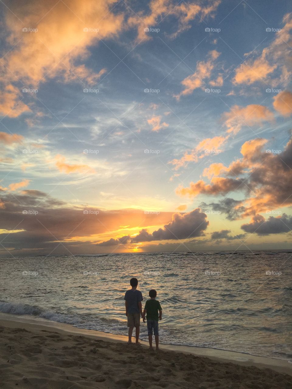 Boys in the beach at sunset