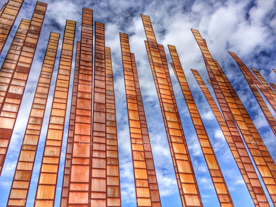 Looking Up at the Clouds . Metal poles against sky