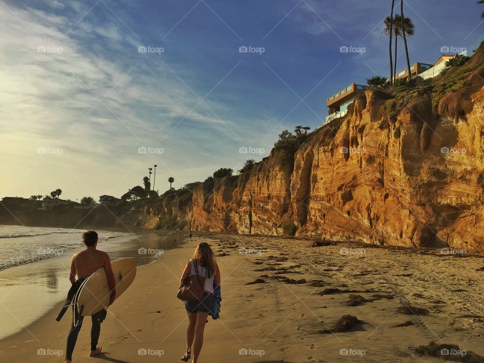 San Diego cliff. Sunset against the cliffs of San Diego with surfers walking by. 