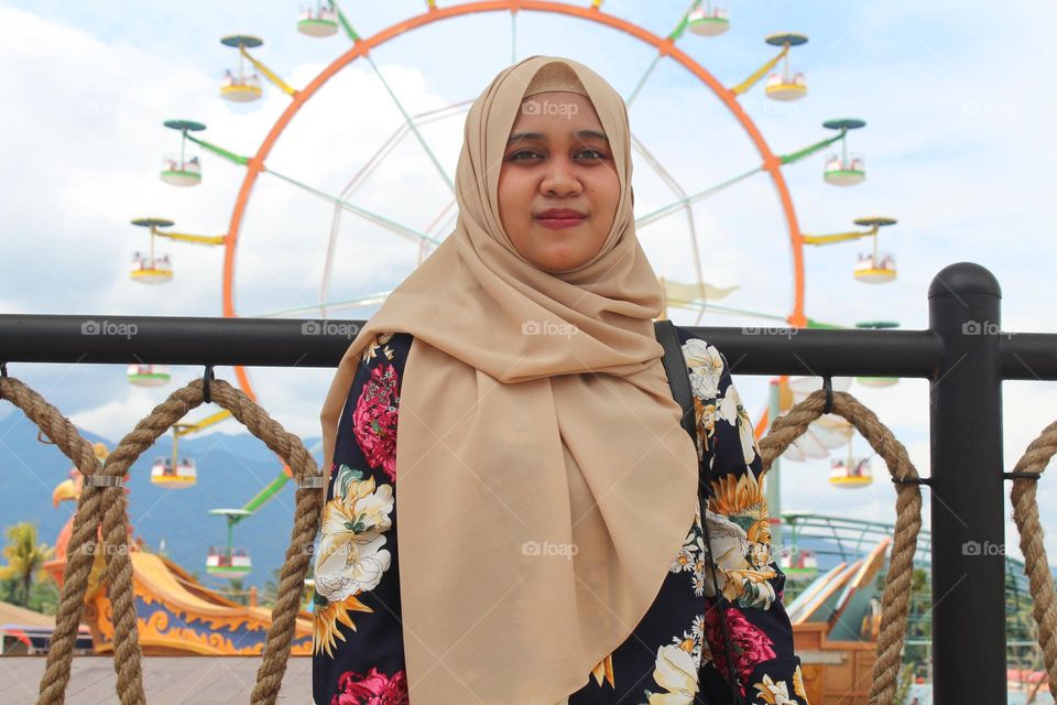 Woman standing with ferris wheel background
