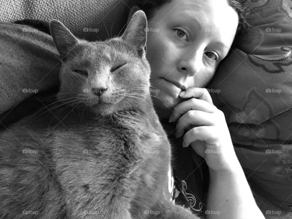 Cat and man lying on sofa