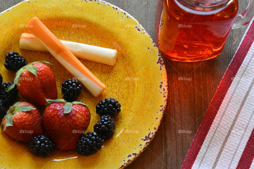 Cheese sticks and fruit with a glass of juice