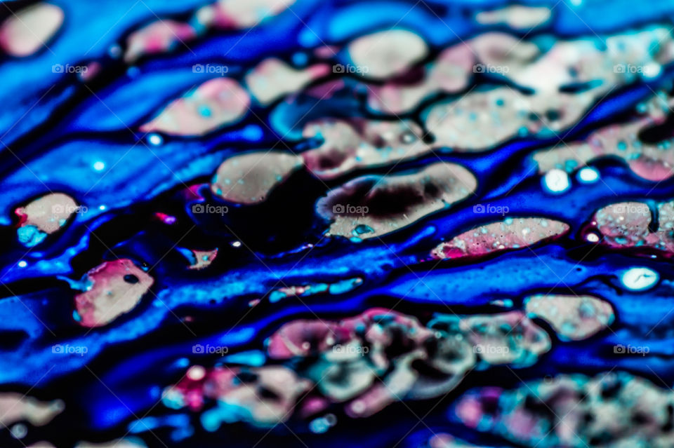 The ink to refill the printer cartridge was spilled onto the white washbasin and the paints blended into abstract drips and patterns.