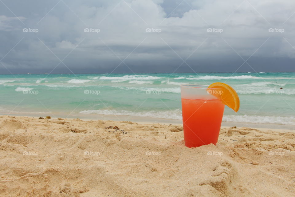 tekila sunrise on the caribbean beach in a stormy day