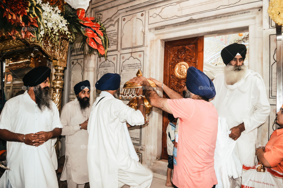 Amritsar, India - MAY 16 2016: Unidentified sikh people decorating idol with ornaments and flower for final make up before Puja. Golden Temple is the holiest Gurdwara of Sikhism.