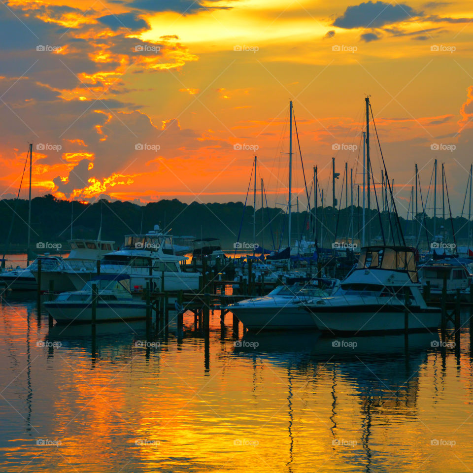 Boats moored at harbor during sunset