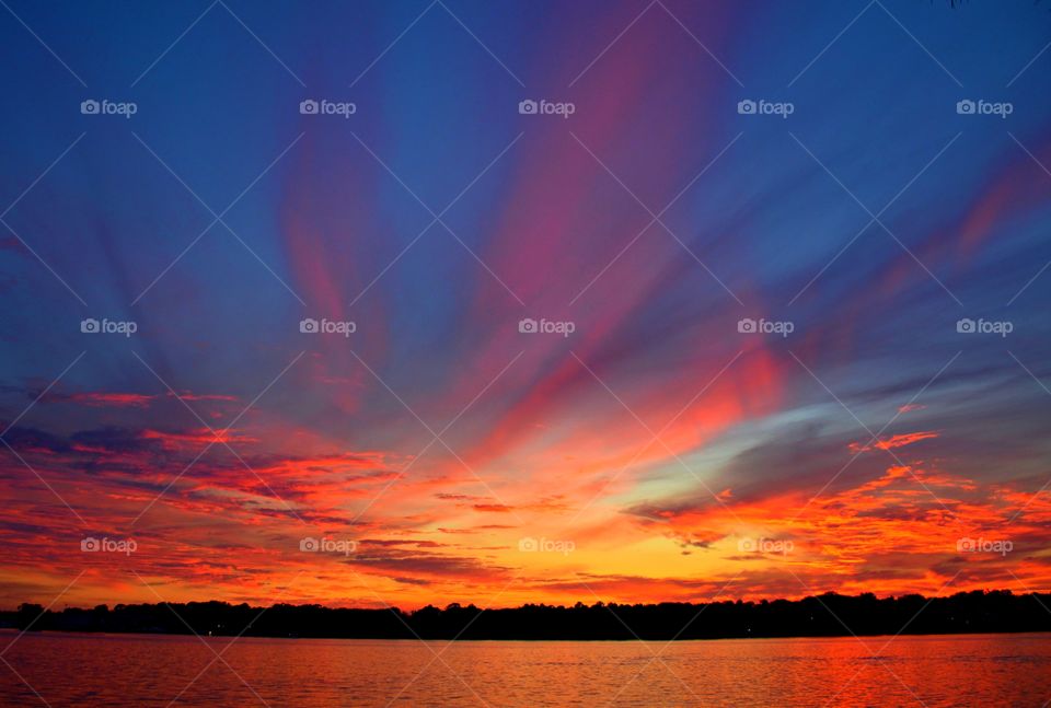 The evening sunset was lighted up with a blue, mauve, explosive pink, yellow and orange radiance, glorious to behold, and increasing in splendor.