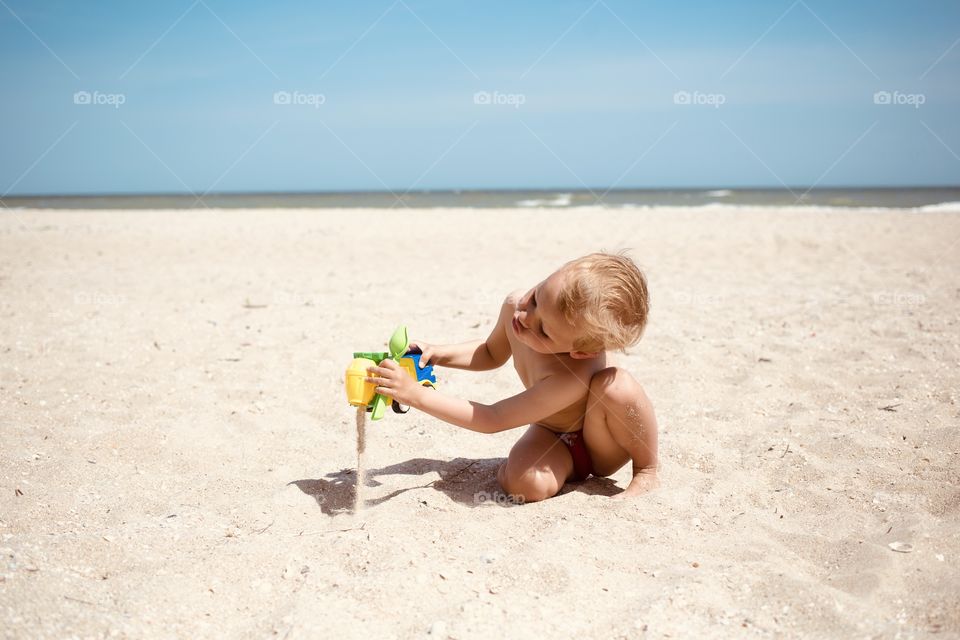 Little boy play at beach with sand and toy car. Happy summer in childhood 👶🏼