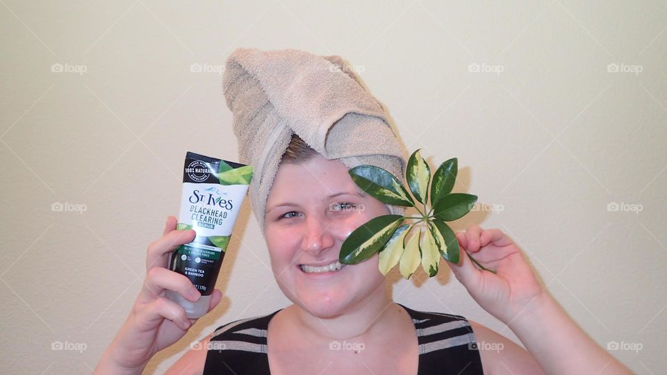 woman towel on hair hand visible holding beauty product