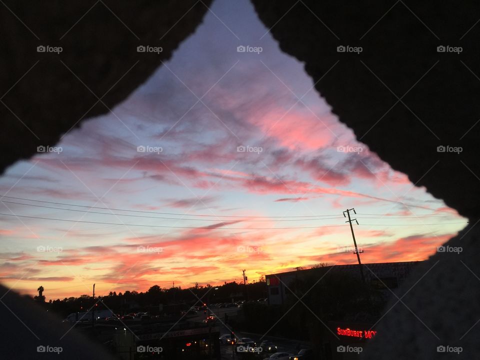 Red streaked sunset thru brick lattice