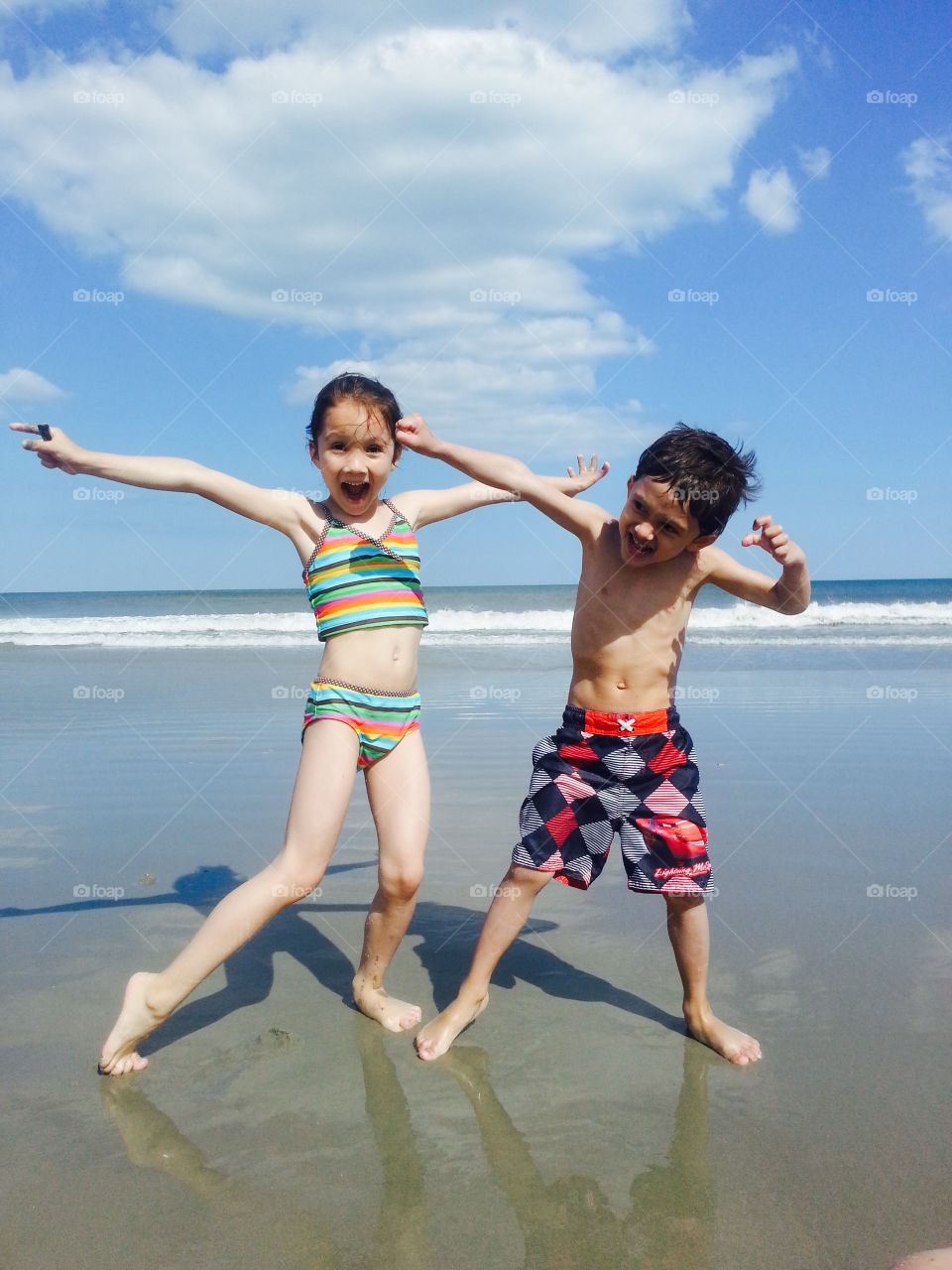 Siblings on the beach having fun.