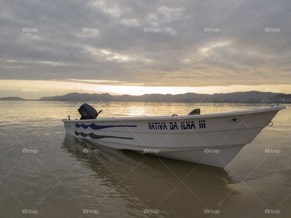 Florianópolis/ Santa Catarina/ Brazil - 07/22/2018: fisherman's boat on the seashore with the sun rising