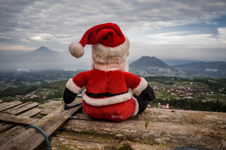 Santa Claus doll with background of the vicinity of the volcano landscape