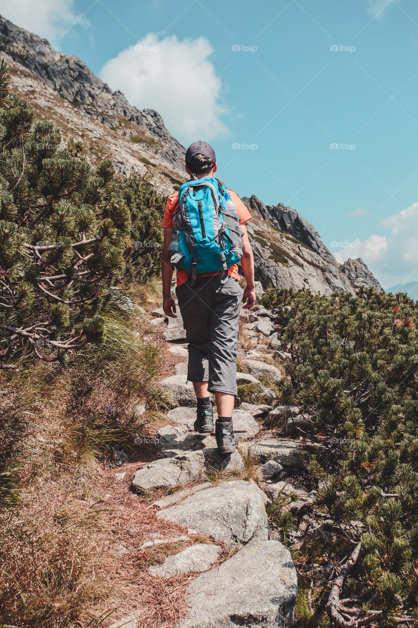 Rear view of man climbing rocky mountain