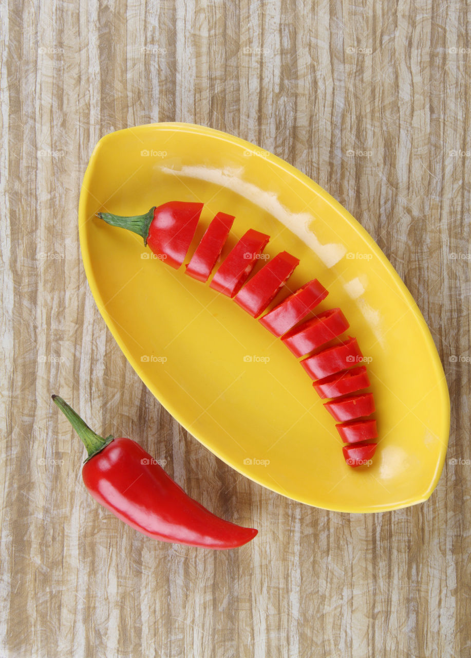 Chopped fresh red chilli on a yellow plate