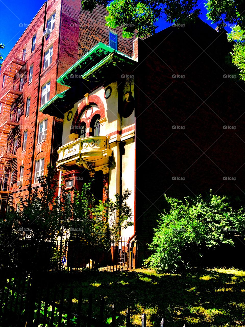 Fort Greene, Bklyn has beautiful old fashioned brownstones with architectural elements from a bygone era, unusual shapes, arches, columns, balconies, stucco ornaments, iron cast art and lush green manicured vegetation. 2020. Hypnotic Productions
