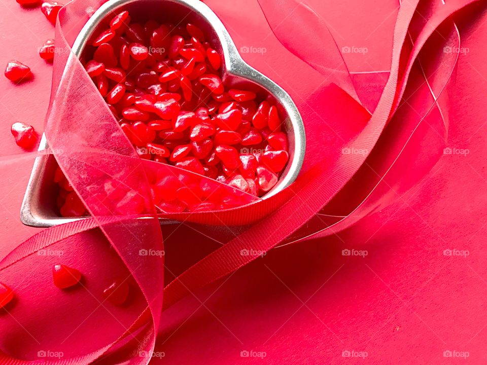 Heart candies with ribbons on red