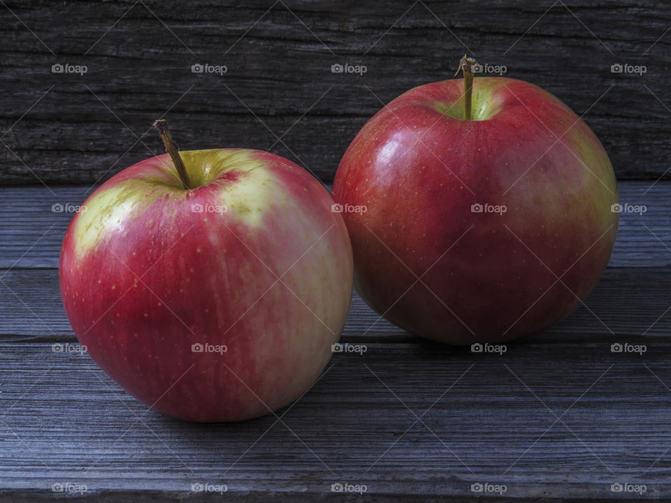 Two juicy ripe red-yellow apples on a wooden table