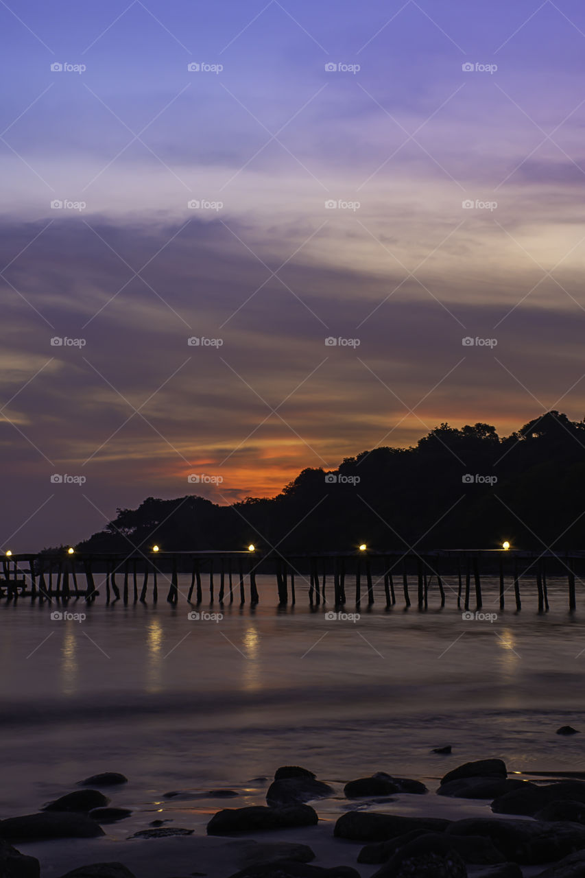 The sunset behind the island in the sea and  wooden bridge at Koh Kood, Trat in Thailand.