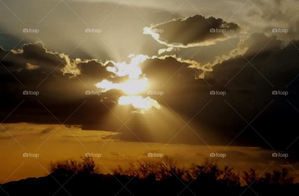 View of sunrays through clouds at sunset