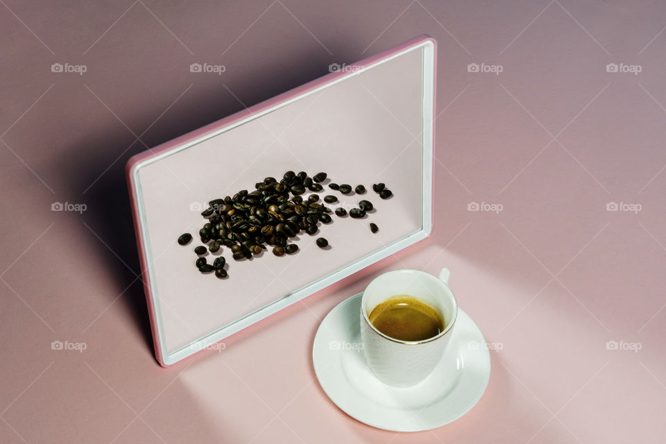Espresso coffe with coffee beans in a mirror reflection