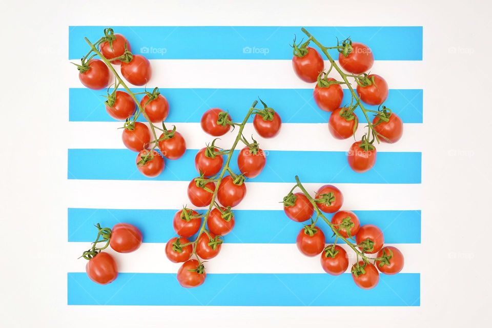 Directly above view of cherry tomatoes on blue and white striped table. 