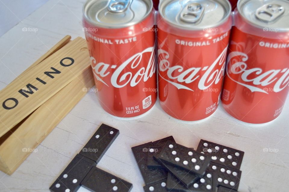 A six pack of Coca-Cola with dominoes