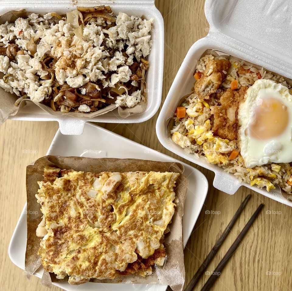 Local hawker asian dishes in cheesy floss carrot cake, crab meat char kway teow and fried rice with chicken and egg