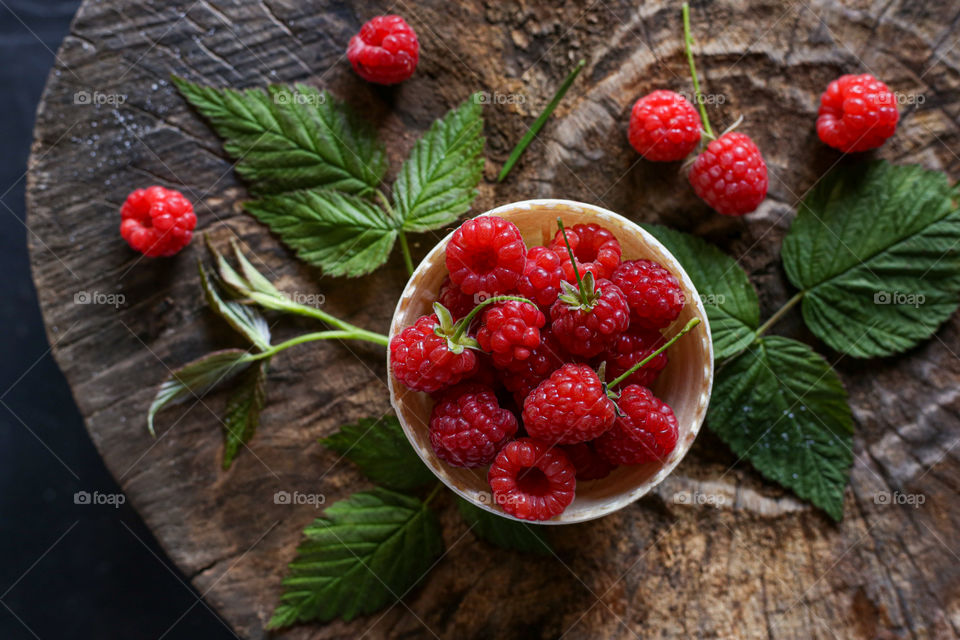 Bright raspberry on the wooden background 