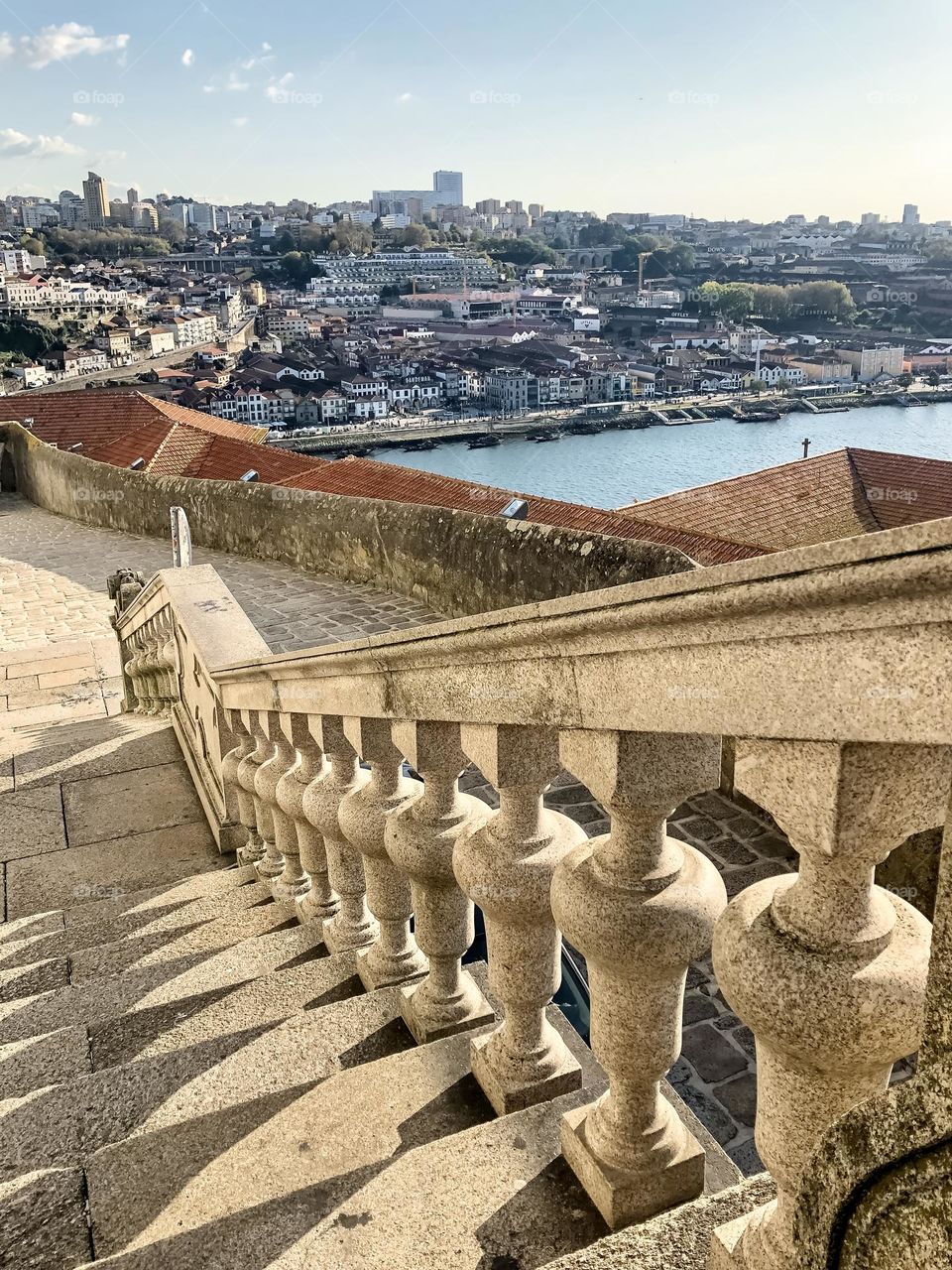 Ornate stone steps lead down to a view of Porto