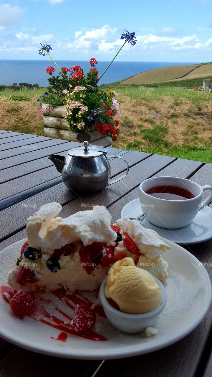 Nice summer day, summer mood, beautiful view and tasty tea with ice-cream and Pavlova cake.