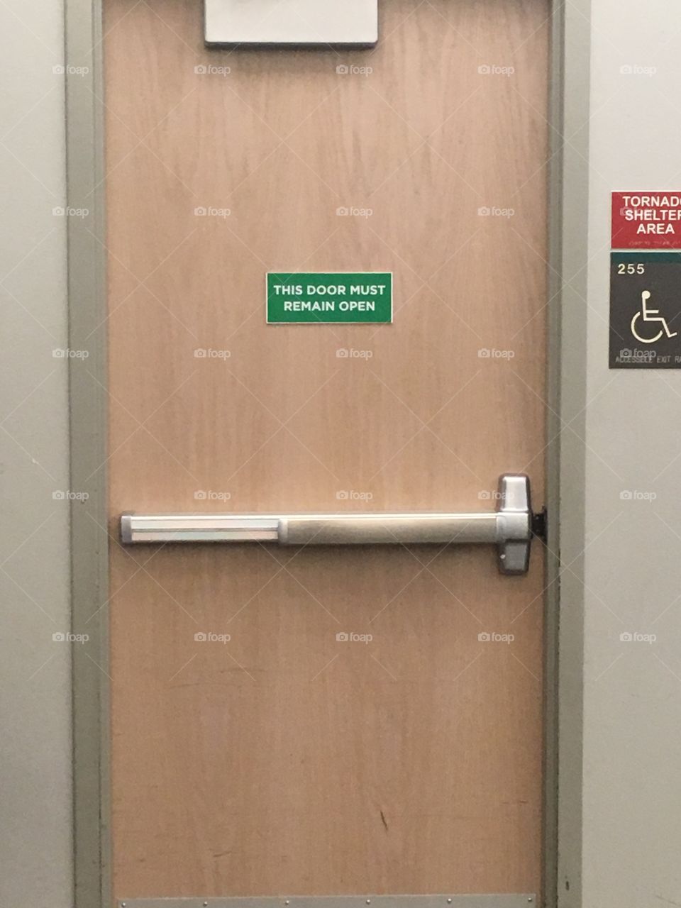 A closed door to a lecture hall at University of North Texas with a sign stating “This door must remain open”
