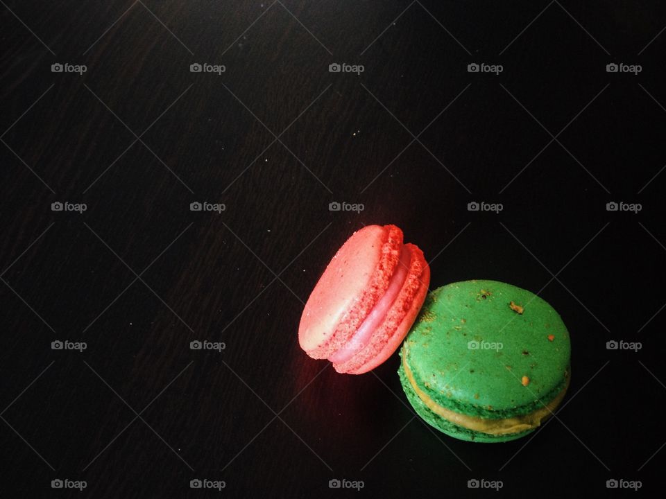 Red and green macarons on a dark background