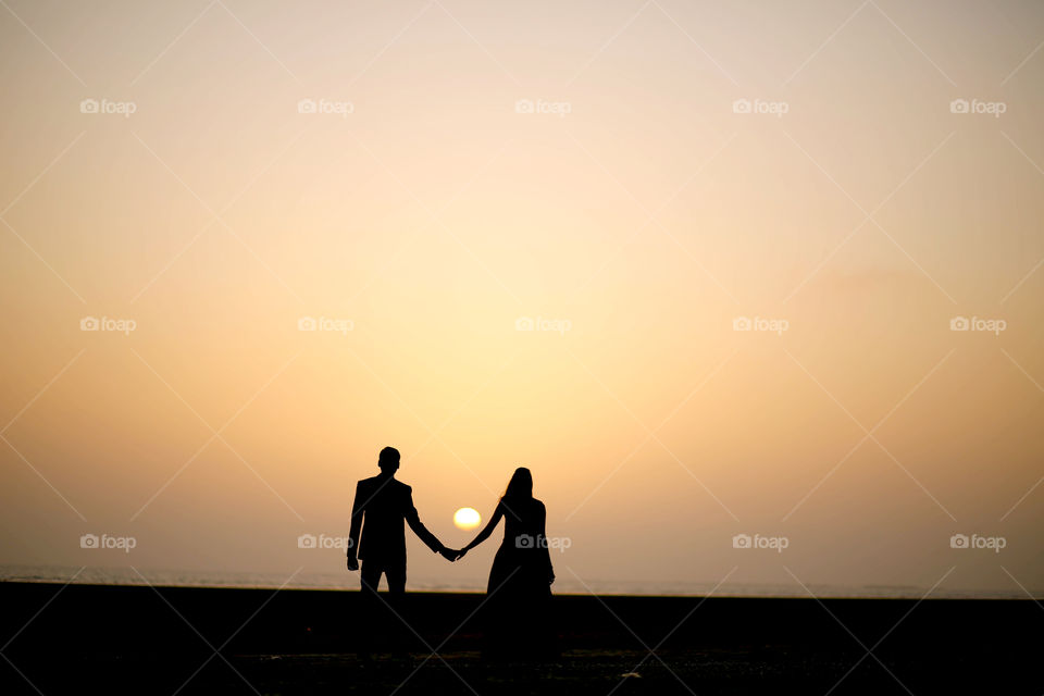 Silhouette of young couple standing during sunset