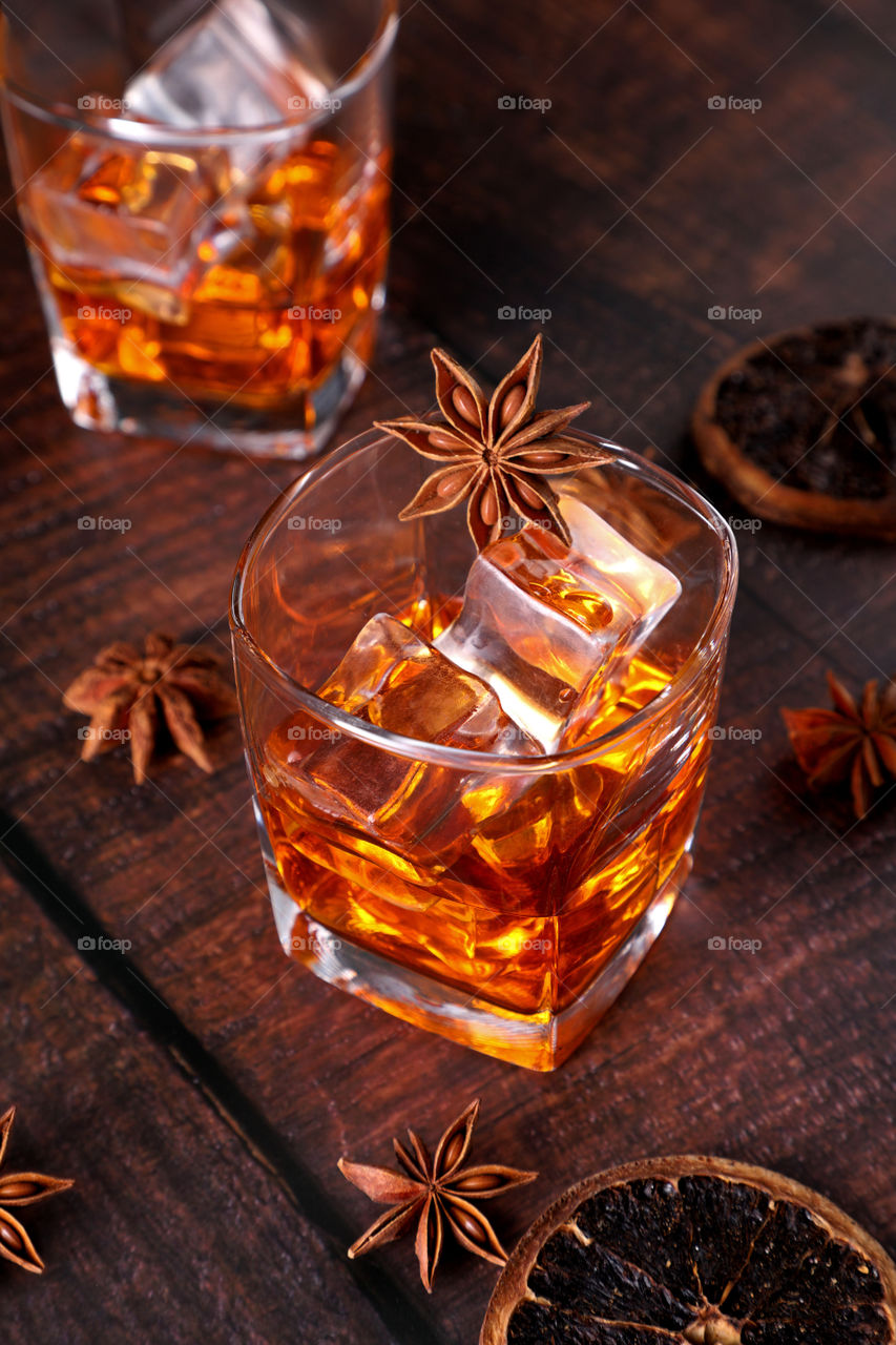 Whiskey or rum, cold drink with ice cubes and spices