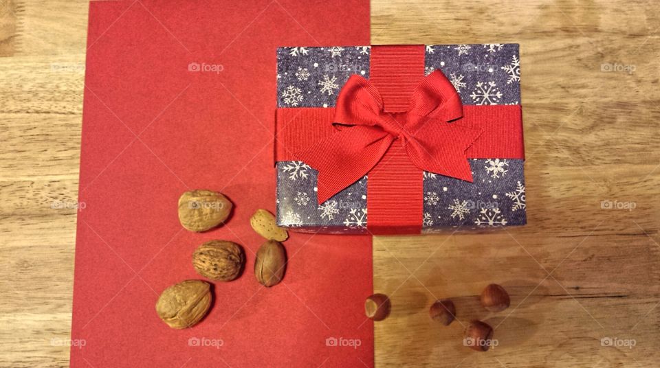 mixed nuts with present and bow on red background