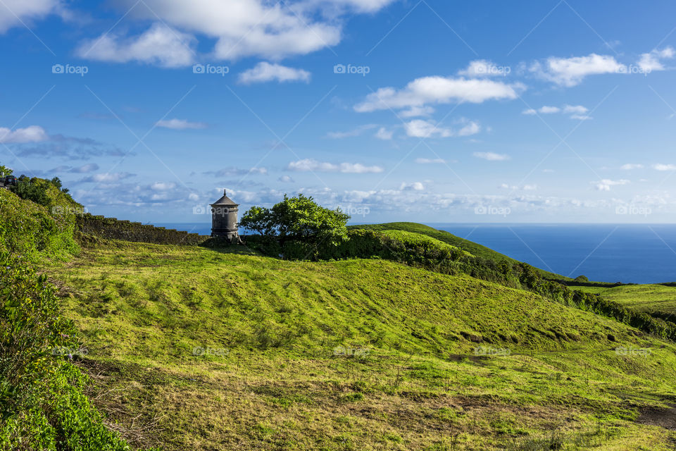 View from the road to Sete Cidades in the island of Sao Miguel, Azores, Portugal. Meadows with ocean in the background.