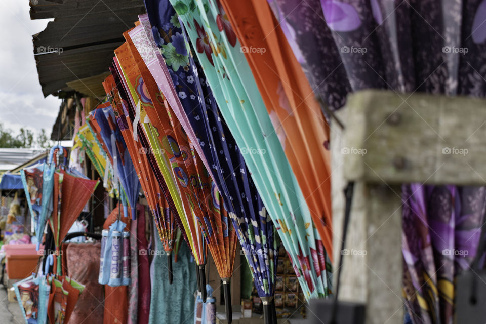 Colourful umbrellas hanging in front of the stall in asia