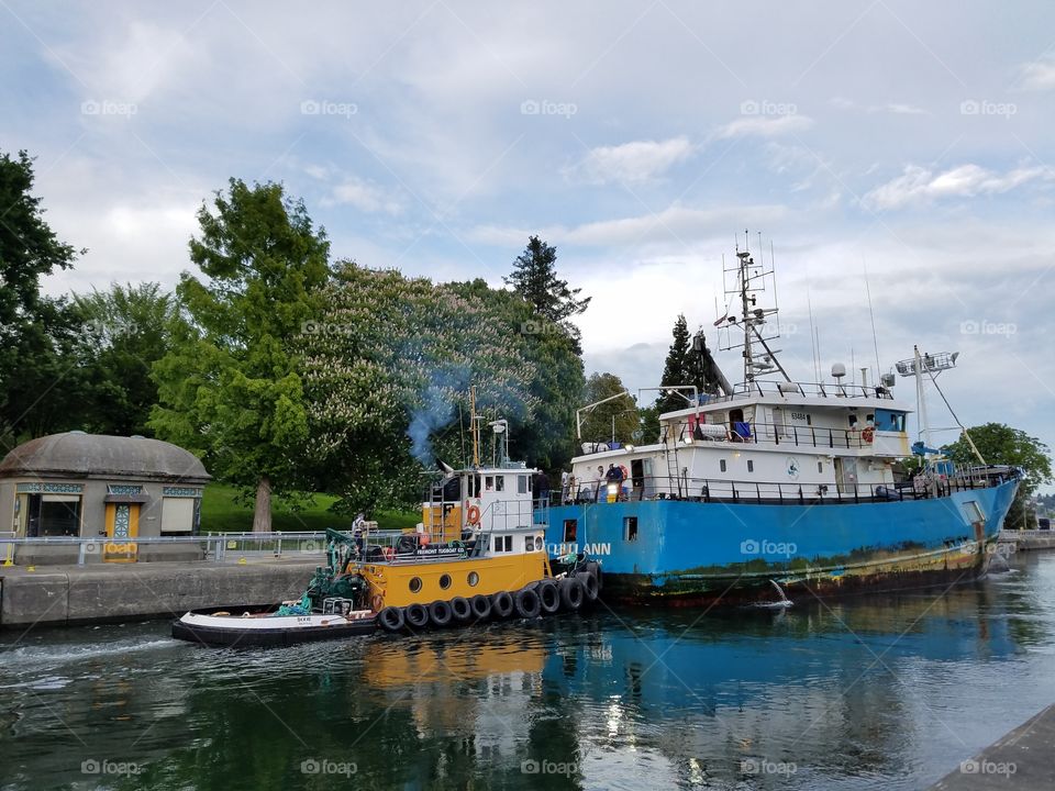 coastal villages Lilli Ann and its tuboat in the western half of the large chamber at Hiram M Chittenden Locks. Seattle, Washington 5/20/2016 also pictured: one of the old control booths for the lock gates.